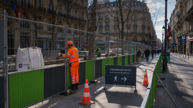 Couloir piéton temporaire sécurisé avec barrières, panneaux et balisage en ville