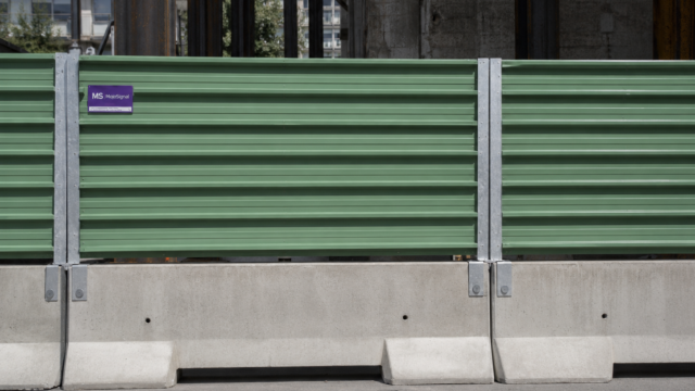 Panneaux de bac acier vert fixés sur des blocs béton de chantier