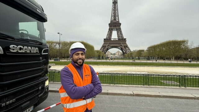 Agent Mojo Signal transportant une barrière métallique devant la tour Eiffel