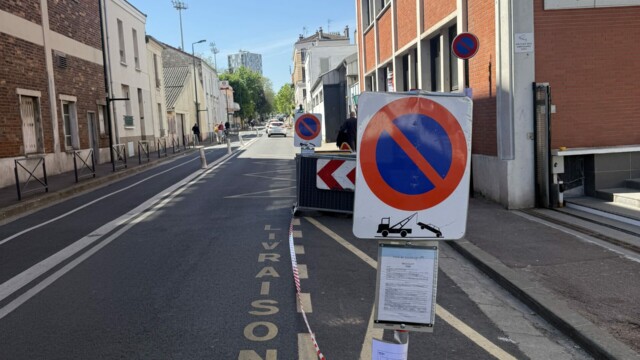 Signalisation temporaire avec arrêté affiché pour neutraliser une zone de stationnement le long d’une rue étroite et préparer l’accueil d’un véhicule ou de matériel d’intervention.