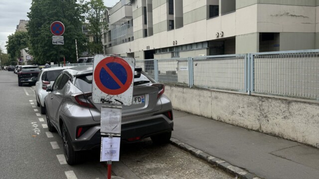 Gros plan sur un panneau temporaire d’interdiction de stationner avec documents réglementaires