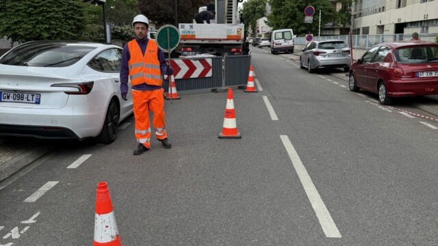 Agent Mojo Signal régulant la circulation avec un piquet K10 sur une rue de Boulogne-Billancourt