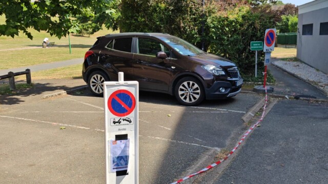 Panneau temporaire d’interdiction de stationner installé dans une rue résidentielle parisienne.