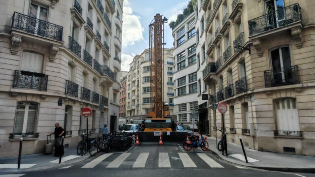 Vue frontale d’une rue fermée avec grue, barrières et cônes de chantier à Paris