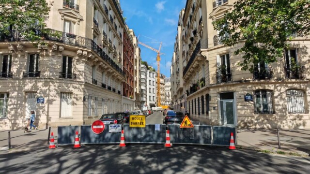 Grue avec stabilisateurs, cônes et rubalise dans une rue du 7e arrondissement de Paris